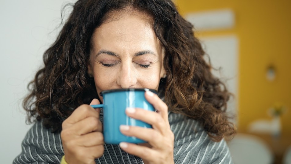 Close-up of woman drinking tea from mug