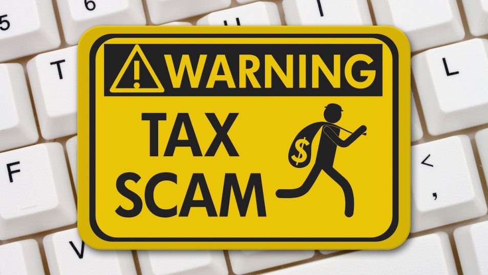 "Warning: Tax Scam" graphic sign on top of computer keyboard