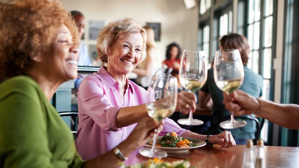 mature women all toasting with glasses of wine, hangover concept