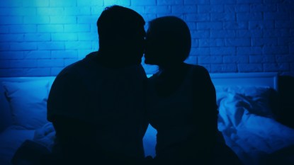 Silhouette of couple in bed at night time