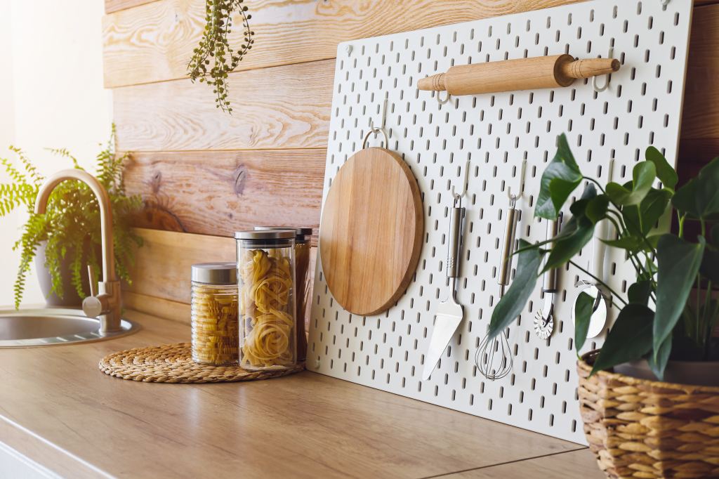 Peg,Board,With,Kitchenware,On,Kitchen,Counter,Near,Wooden,Wall