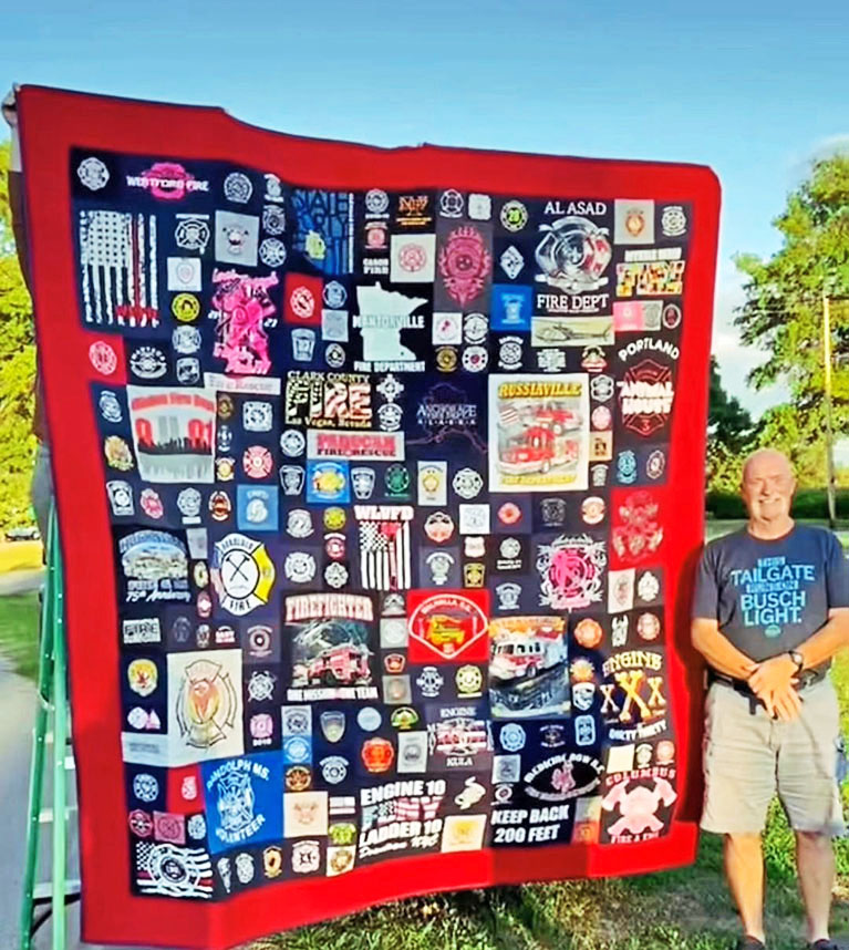 Retired firefighter, Bill Collins, with the firefighter quilt his daughter, Ali, made for him