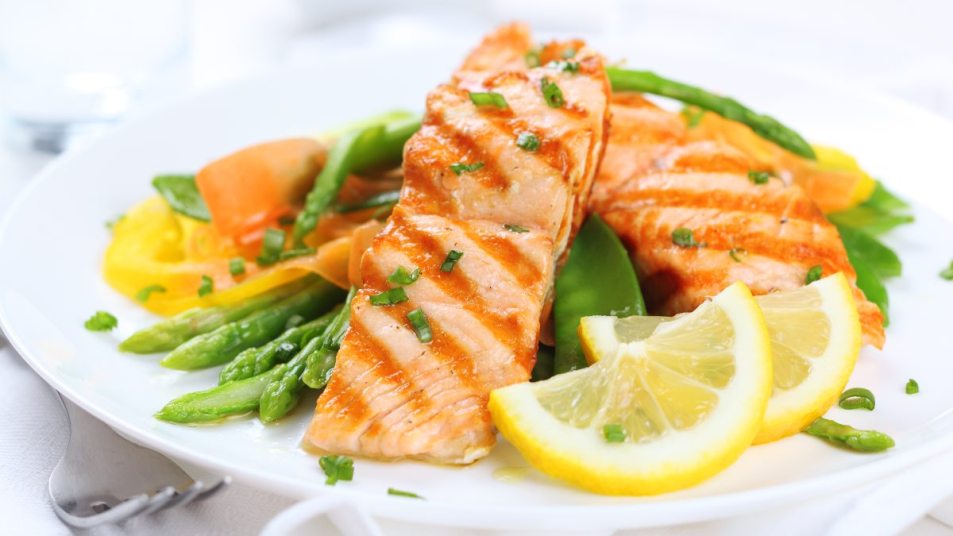 Grilled Salmon dinner with asparagus, peas, and lemon slices, 'repair your GI tract' concept