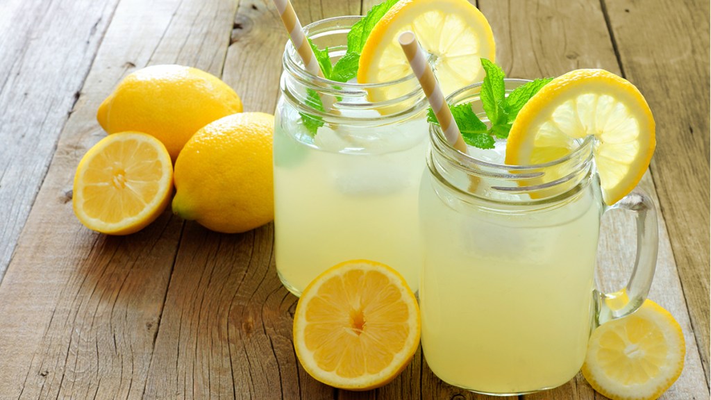 two glasses filled with lemonade and mint