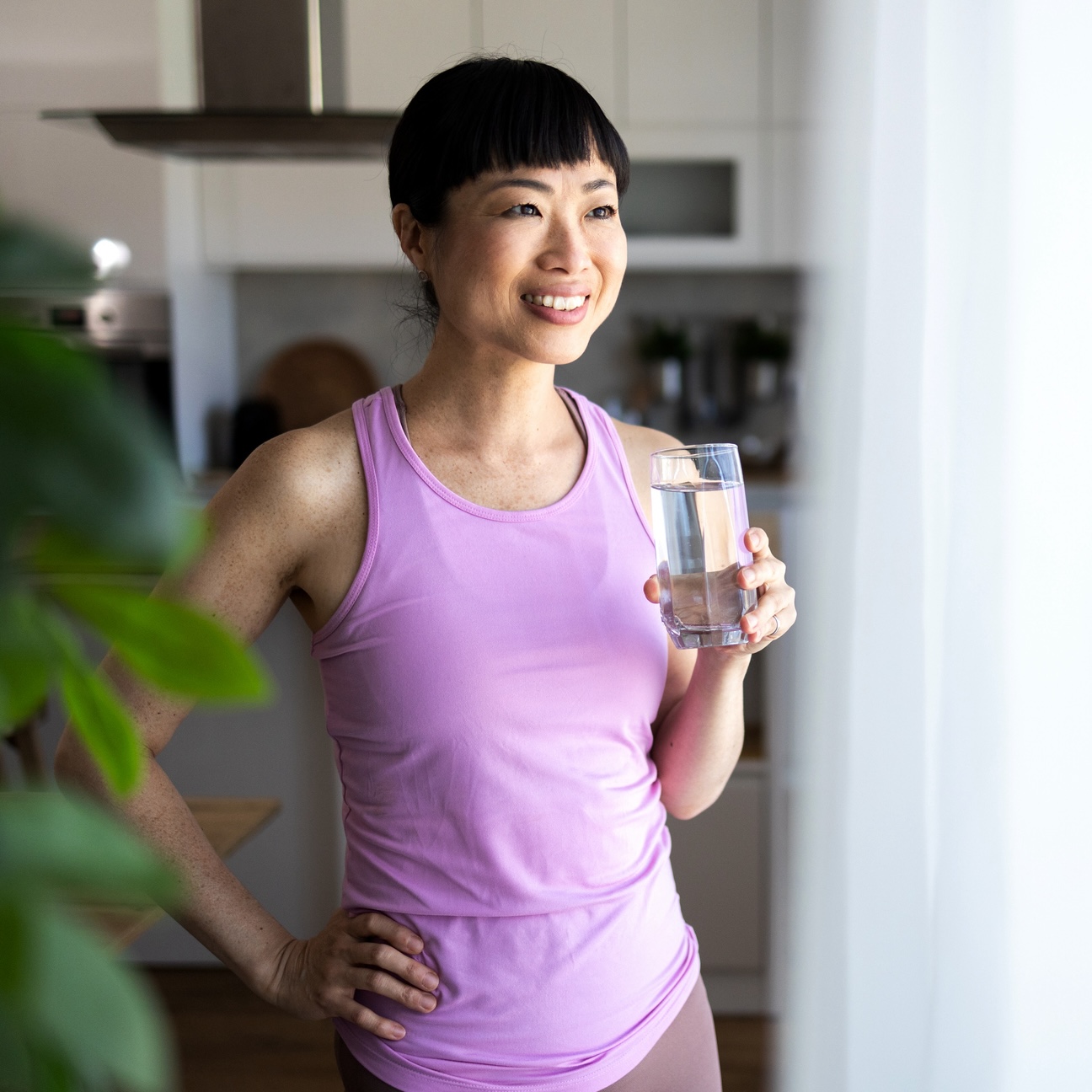 mature woman drinking glass of water to lose water weight