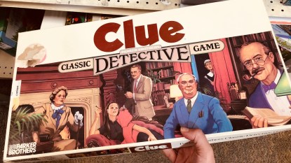 Hand holding vintage Clue board game