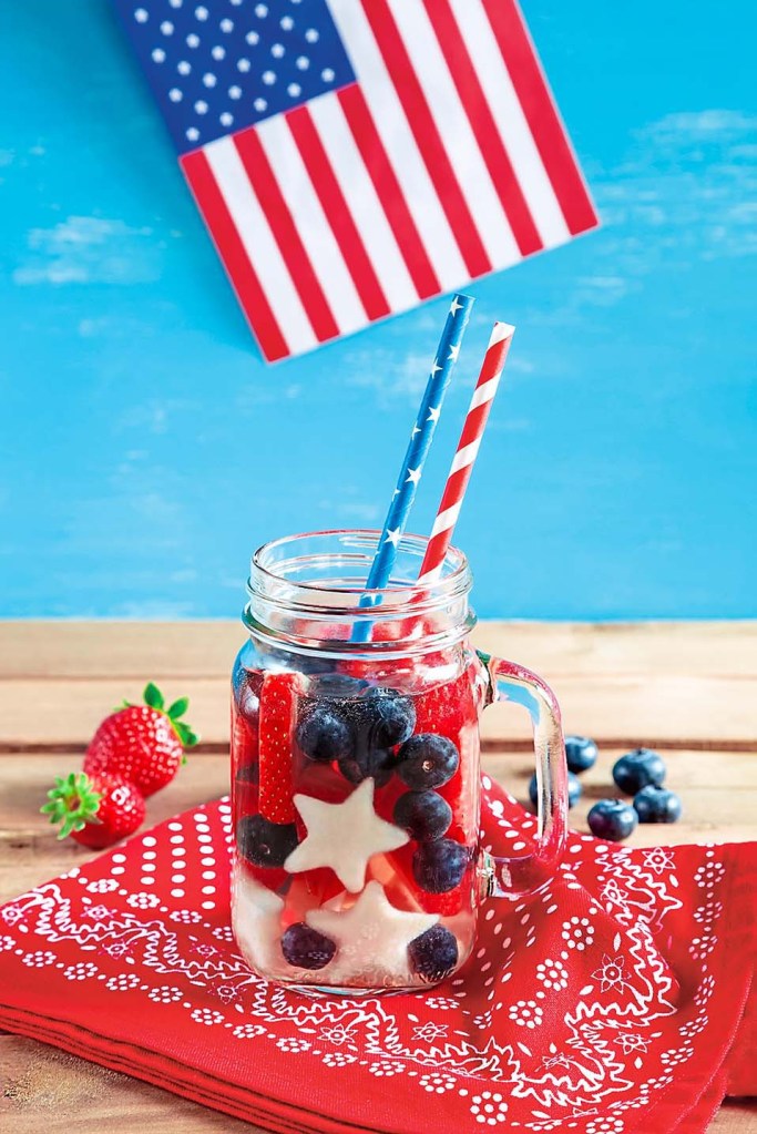 cocktail in a mason jar with red, white and blue garnishes and American flat