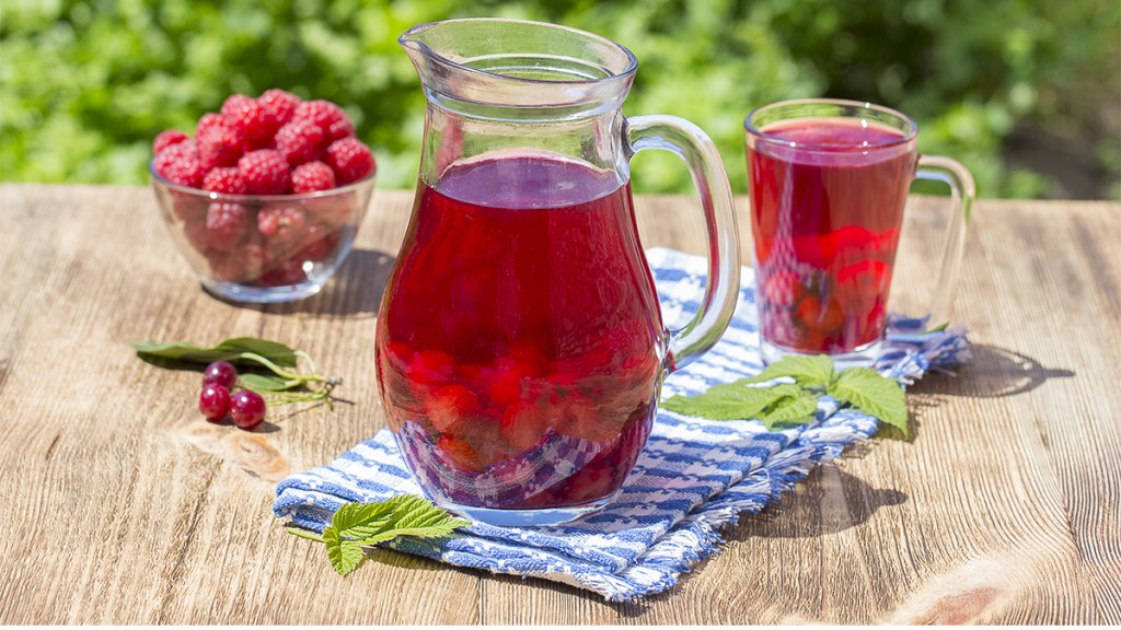 pitcher of red drink with raspberries