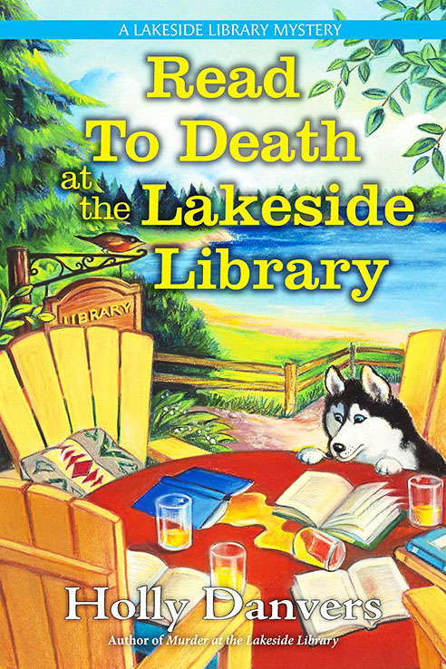 Book cover of Read to Death at the Lakeside Library
by Holly Danvers. This cover shows a colorful lakeside scene with chairs and a table with a dog sitting nearby
