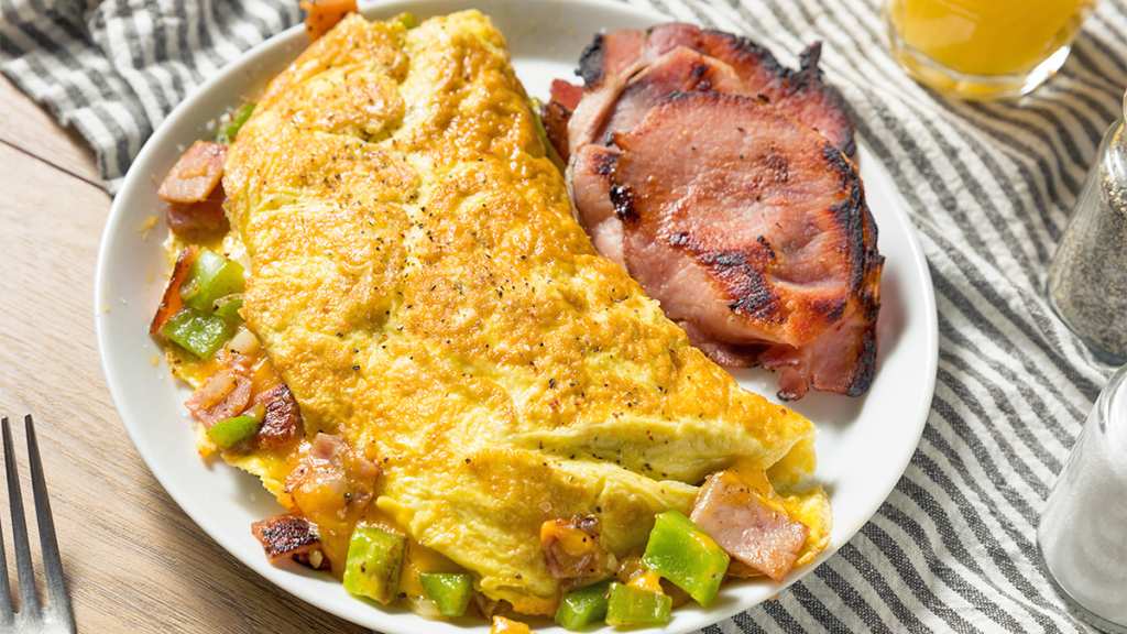 A Denver omelet served on a plate with a side of extra ham