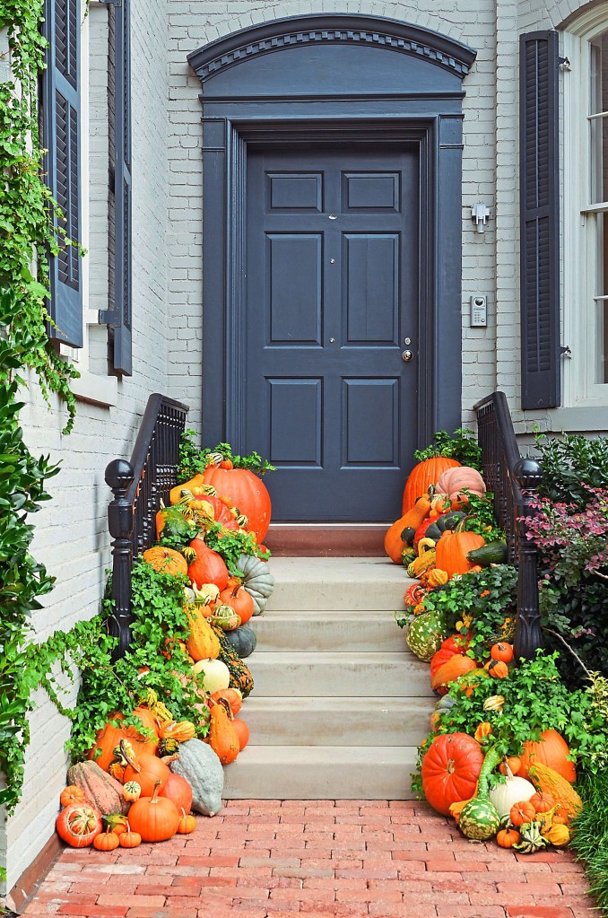 Halloween door decorations: lines of pumpkins and gourds leading up steps to front door
