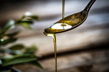 Olive oil being poured on spoon