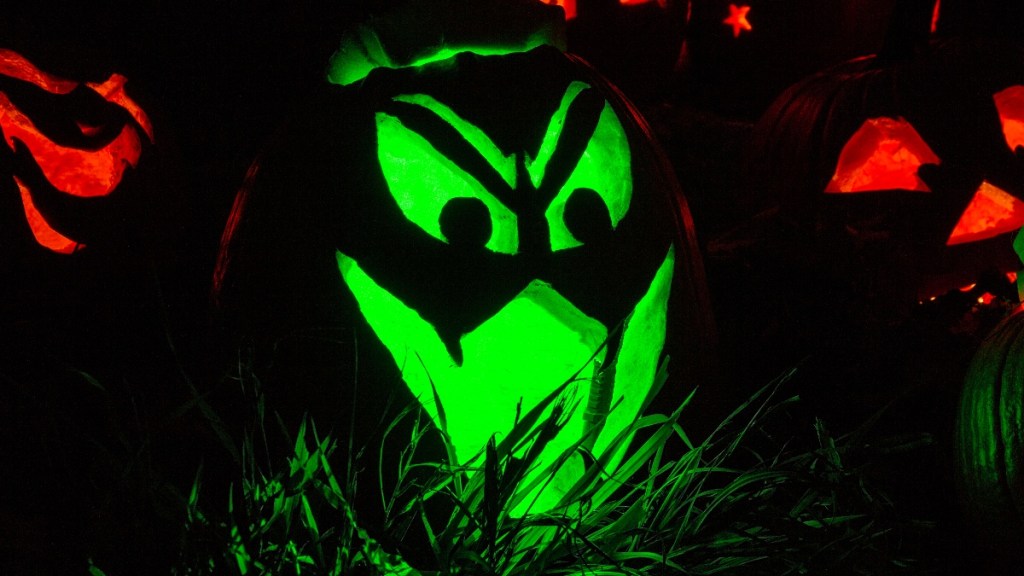 Jack O'Lantern faces: one lit with a green tea light