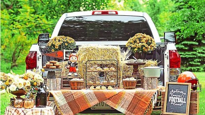 Tailgate party in back on pickup truck with flowers and snacks and blankets