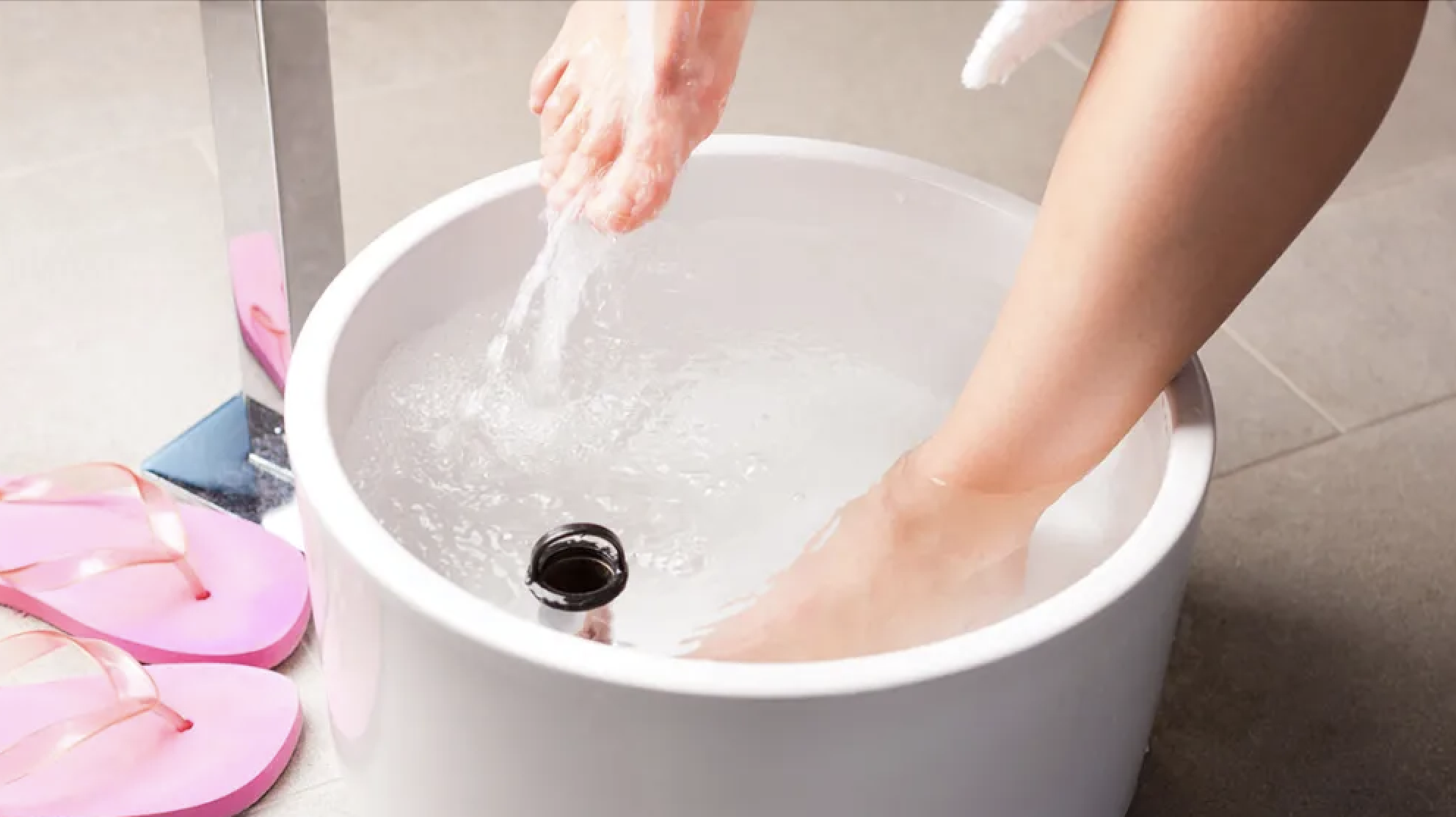 woman soaking feet to stop foot pain from standing all day