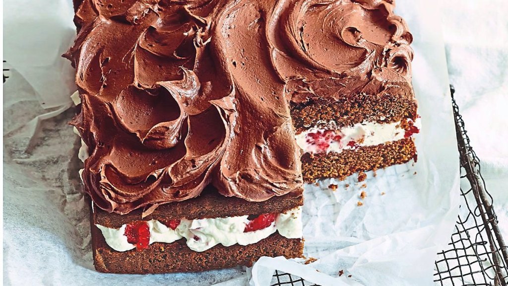 Raspberries ‘n’ Cream Chocolate Cake sits on a white table cloth