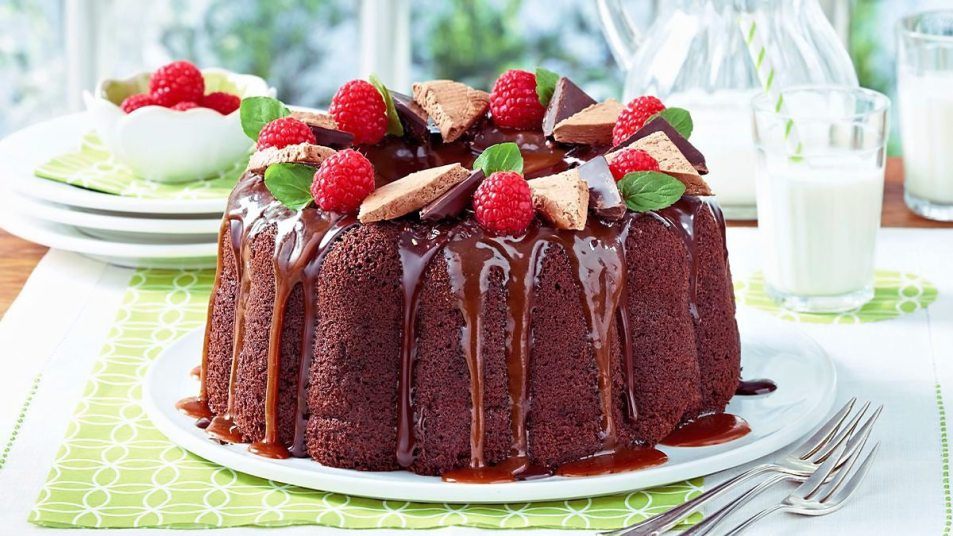 Chocolate Caramel Bundt Cake sits on a table by some milk
