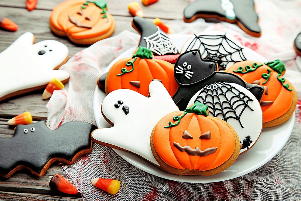 Adult Halloween Party: Festive Halloween Cutout Sugar Cookies in Pumpkin, Ghost and Spiderweb shapes on plate