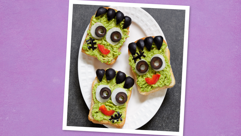 Frankenstein Avocado Toasts sits smiling (halloween dinner ideas)