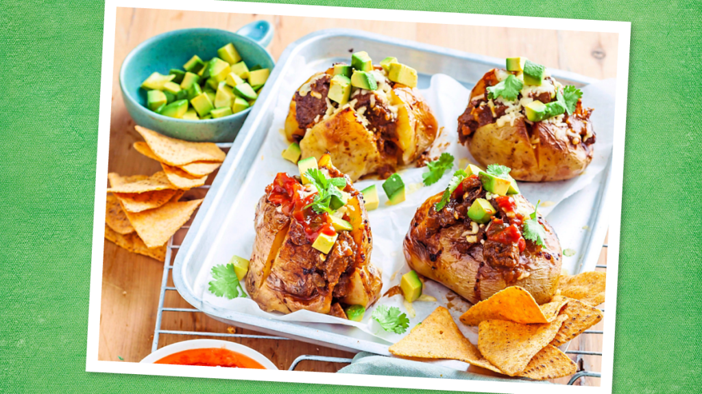 Chili-Stuffed Potatoes sits on a white plate (game day slow cooker recipes)