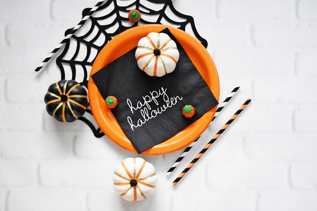 Adult Halloween Party: Festive Orange Place Setting atop faux spiderweb decor