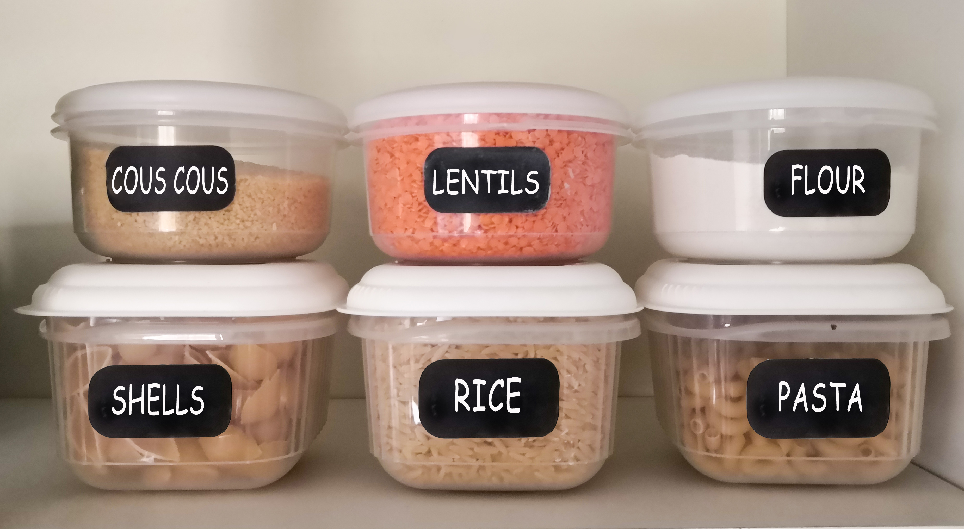 labeled food boxes in plastic containers in pantry