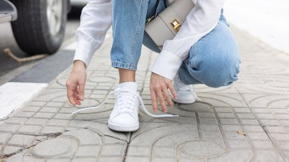 A woman wearing clean white sneakers that have been cleaned to get the smell out