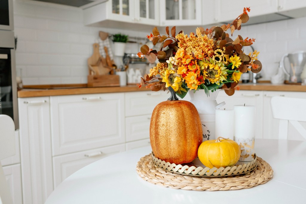 Dessert party: Autumn decor on the table with golden leaves and pumpkins vignette