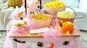 Halloween Movie Night: A low-profile table set with popcorn, twinkle lights, pumpkins and movie night snacks
