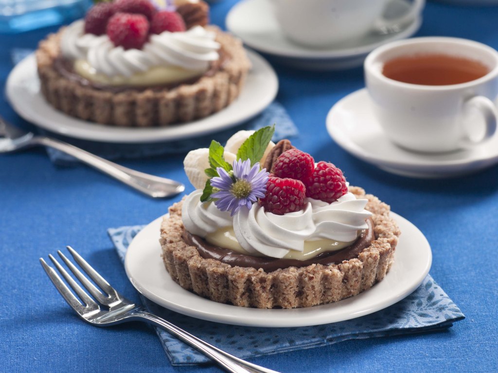 Choco-Banana Pudding Tartlets topped with whipped cream and raspberries