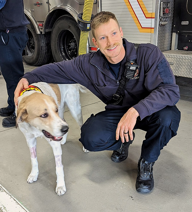 Koda posing with the firefighter who saved him