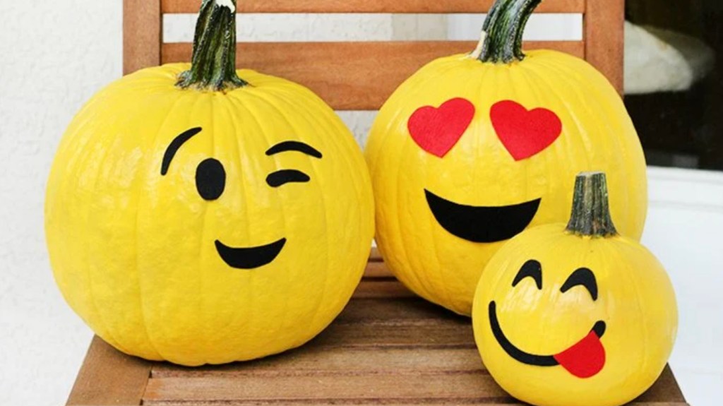 Pumpkins painted yellow and decorated with foam features to look like emojis