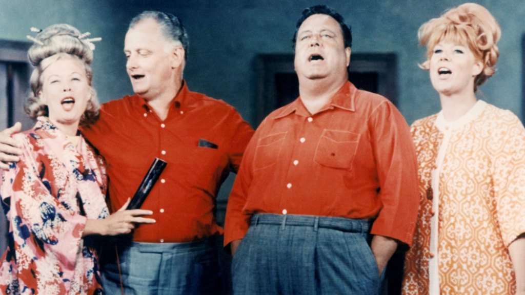 Joyce Randolph, US actress, Art Carney (1918-2003), US actor, Jackie Gleason (1916-1987), US actor, and Audrey Meadows (1922-1996), US actress, stand in a group singing in an image issued publicity for the television series, 'The Honeymooners', USA, circa 1955.
