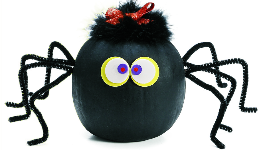 Pumpkin decorated to look like a spider with paper eyes and pipe cleaner legs