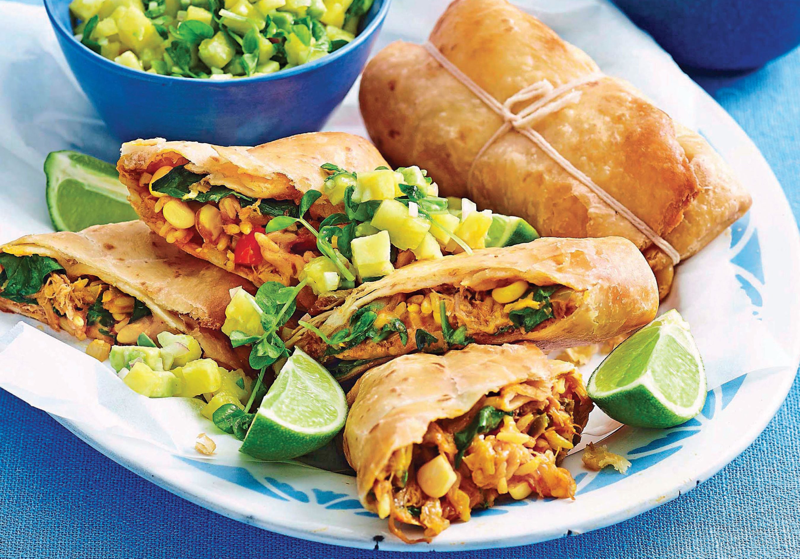 chimigangas recipe on white plate against blue background