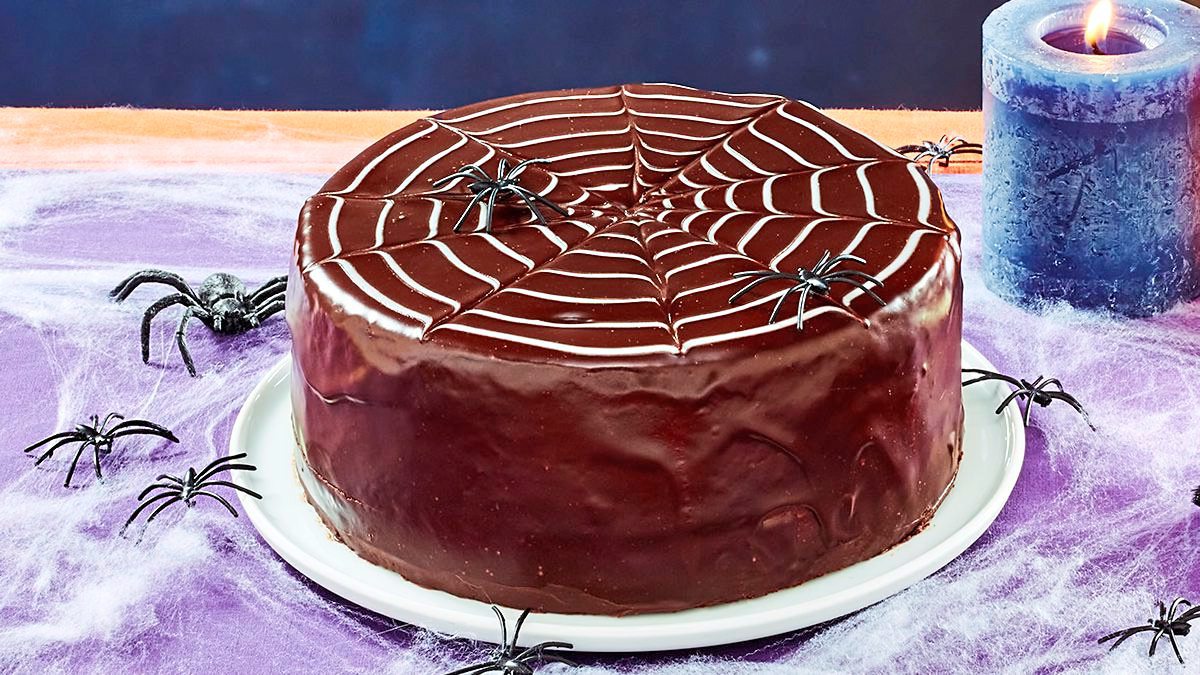 Chocolate Spider Web Cake sits on a purple table (halloween cakes)