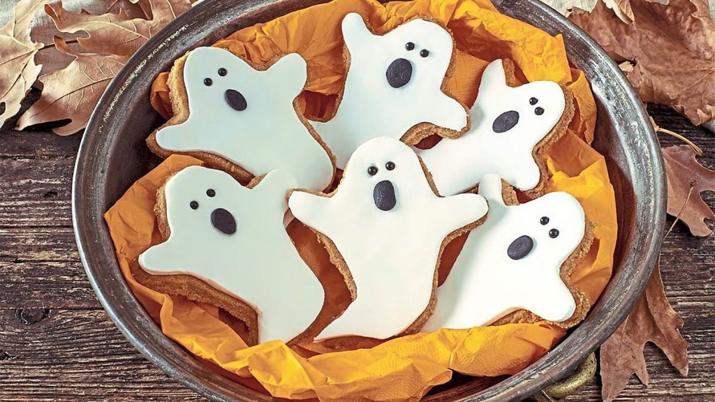 Ghost Gingerbread Cookies sits in an orange bowl (halloween cookies)