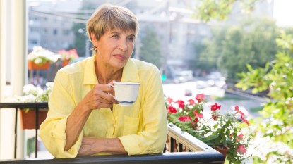 Woman holding mug on balcony