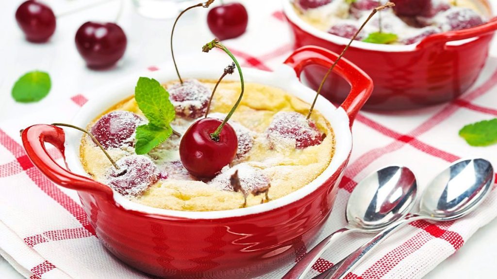 Mini Cherry-Almond Clafoutis sits in a red bowl (5 minute desserts)