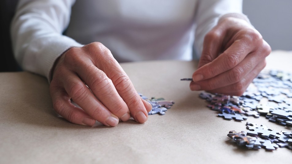 woman putting together jigsaw puzzle