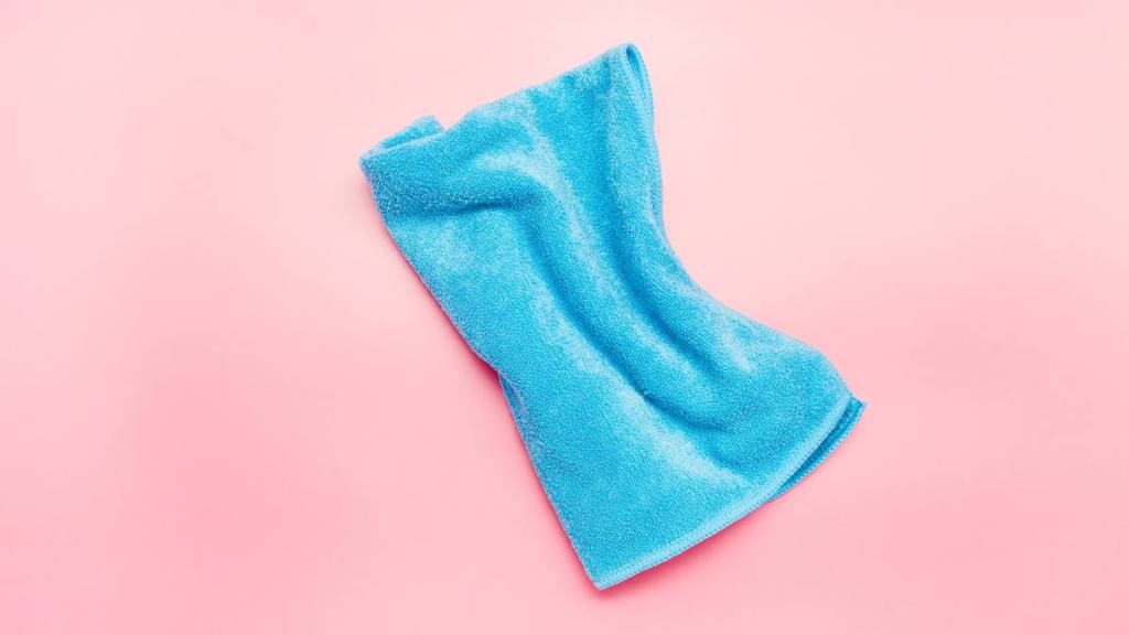 How to clean headphones: Blue cleaning cloth on pink background, house cleaning
