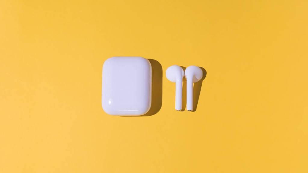 How to clean headphones:Trendy cordless white headphones on yellow background