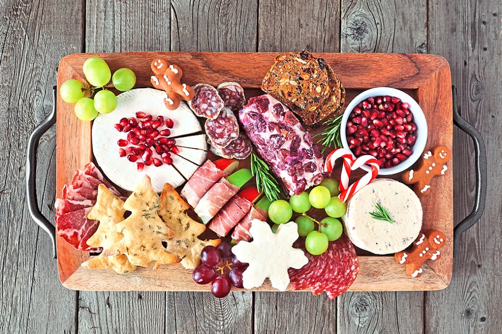 Wreaths decorating party: Holiday charcuterie board on wooden tray placed on table