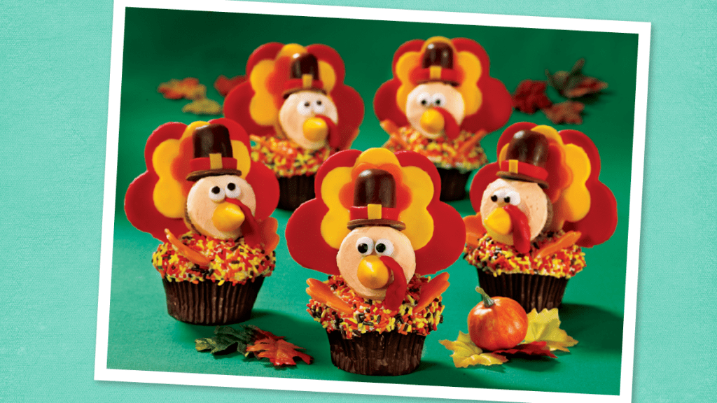 Turkey Pilgrim Cupcakes sits on a green background (Thanksgiving cupcakes)