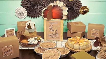 What to do with Thanksgiving leftovers: FEATURED IMAGE lead tabletop that shows to-go boxes and festive paper decor on tabletop