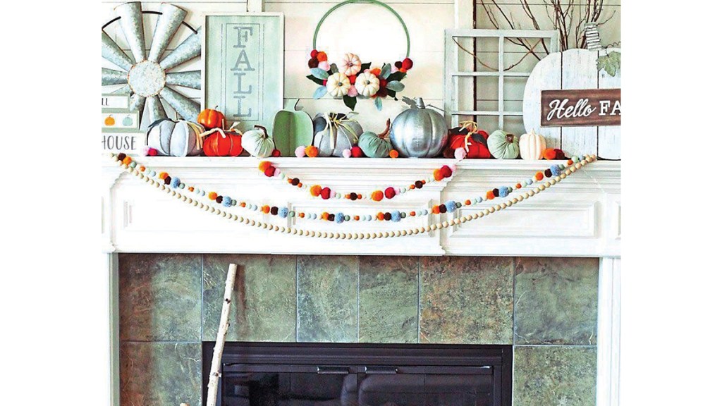 Fall mantel decor ideas: White fireplace mantel decorated farmhouse style with window frames, windmills, colorful pom-pom and wooden bead garlands.