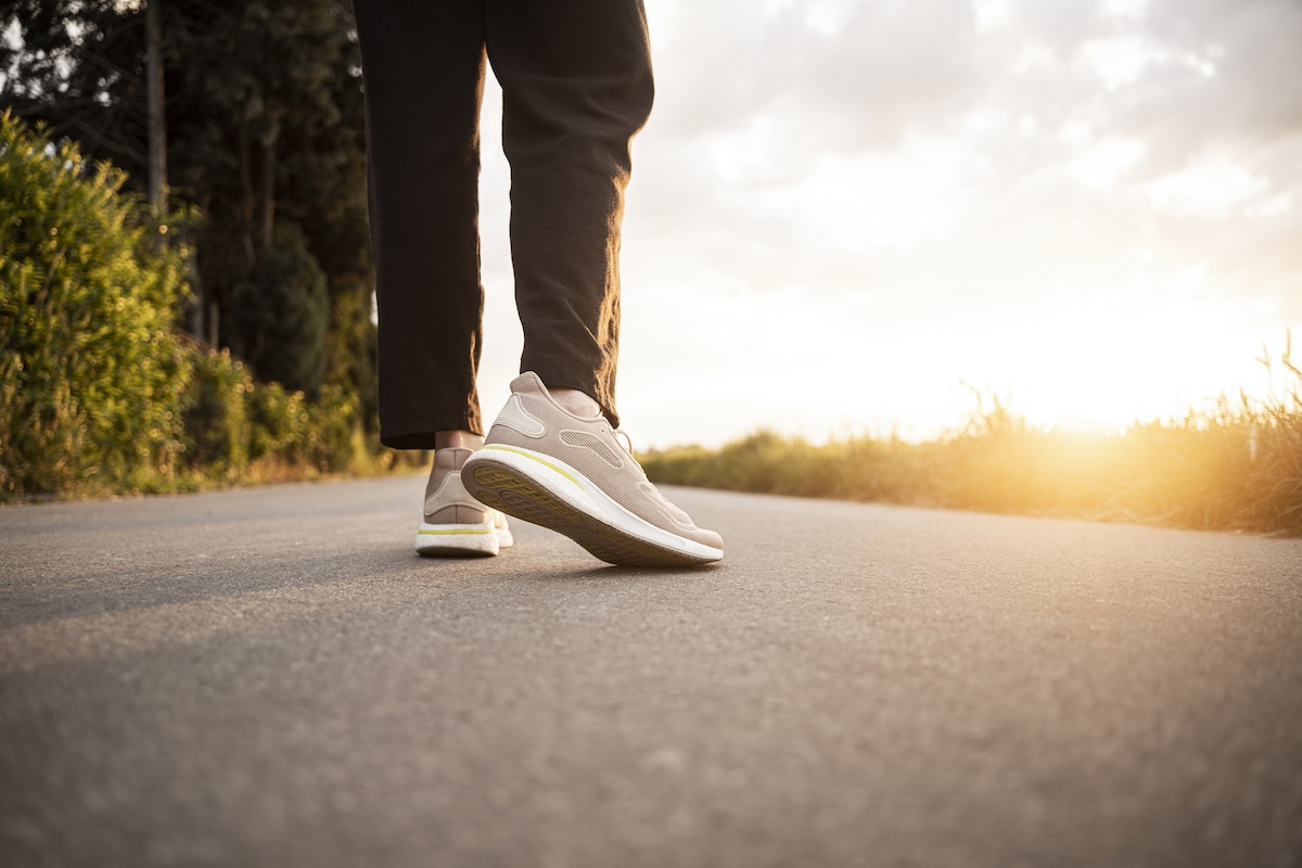 Mid adult woman walking on road during sunset