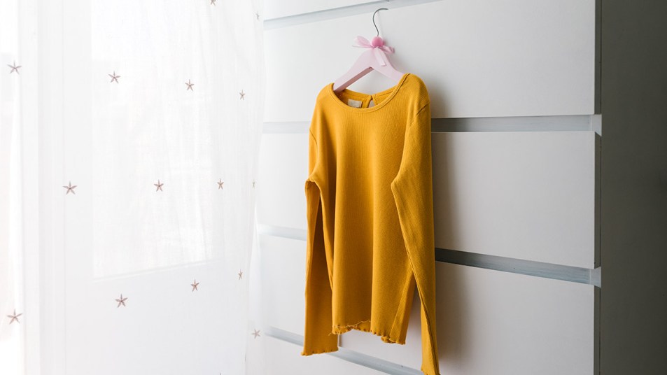A light orange sweater on a hanger after having its bad smells removed