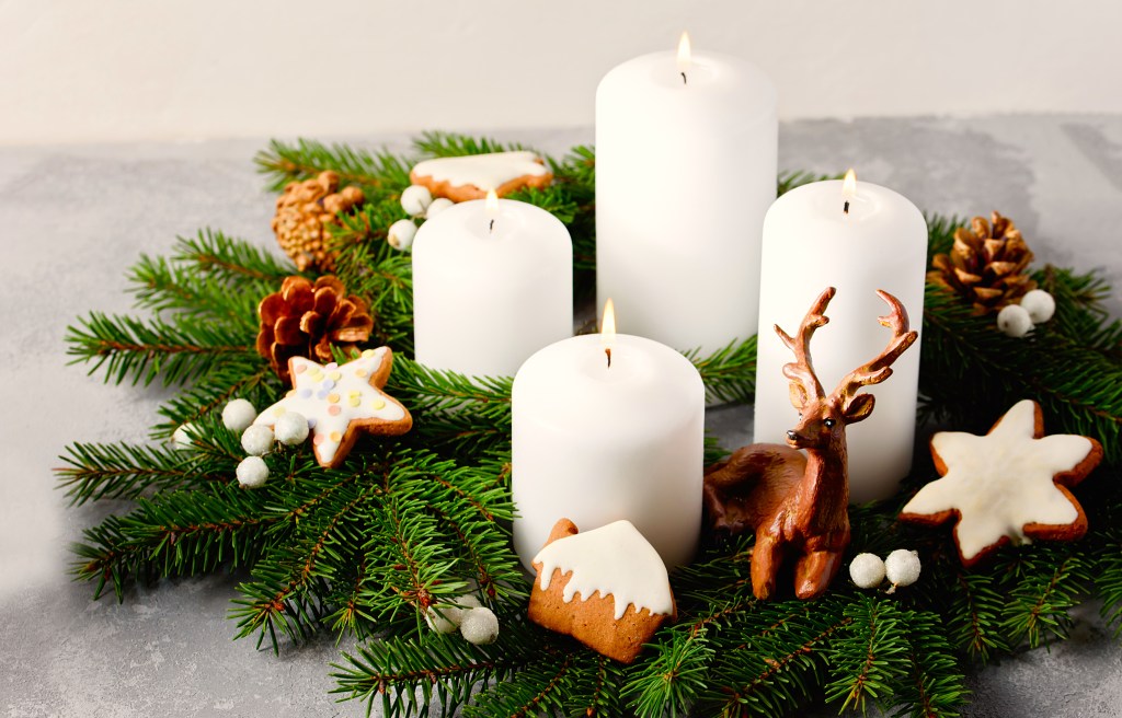 Wreaths decorating party: Four burning white advent candles in advent wreath decoration on light background. tradition in time before Christmas. Xmas lights with Christmas fir deco background concept. Festive still life.