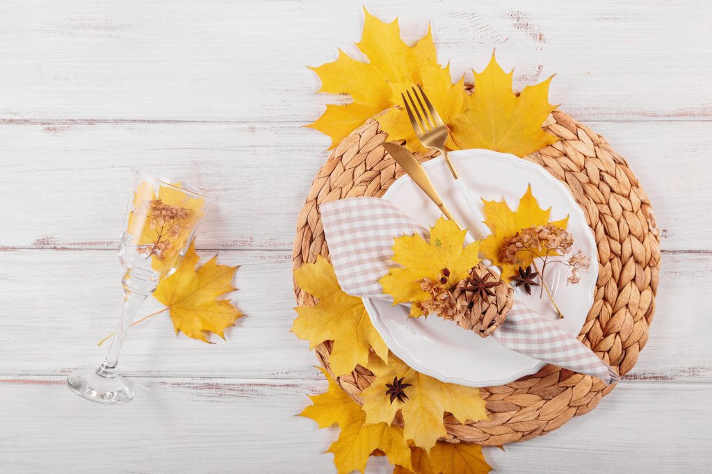 What to do with Thanksgiving leftovers: A fall place setting with autumn leaves on a wicker charger